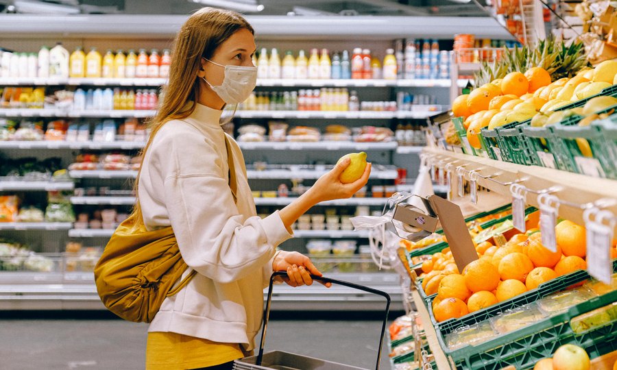 Pessoa escolhendo produtos no supermercado para economizar