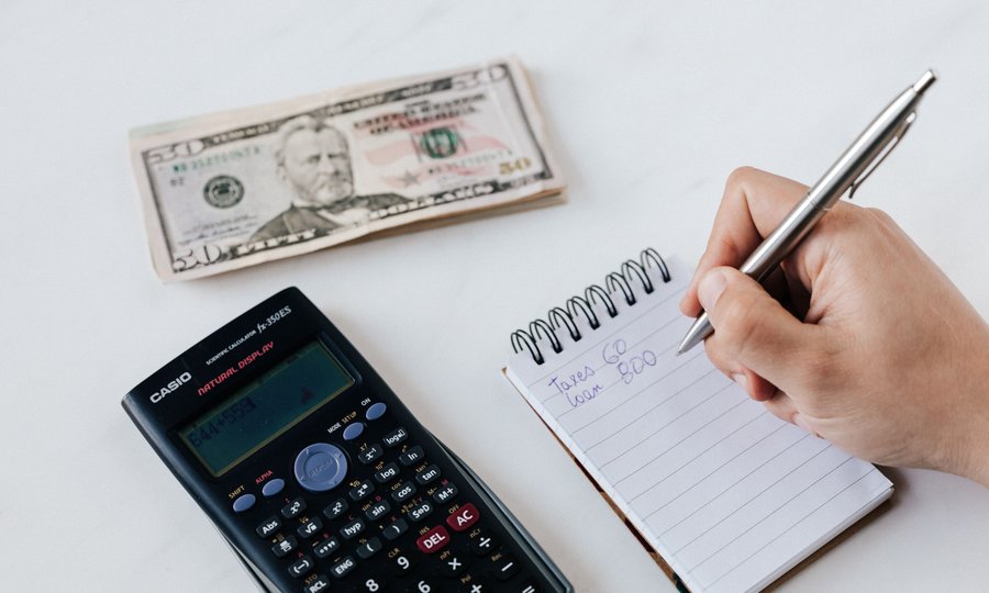 Calculadora e anotações para calcular o valor do abono salarial