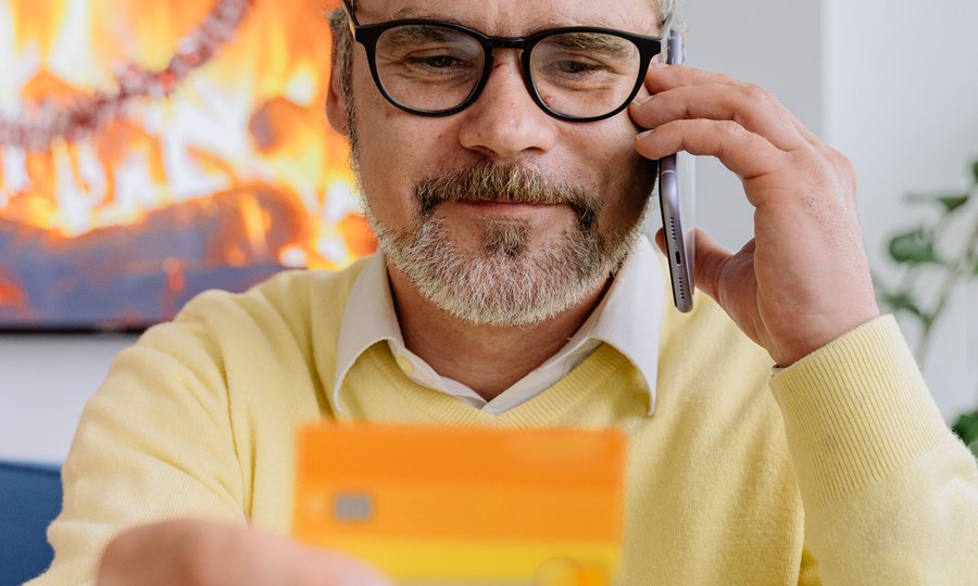 Aposentado segurando cartão consignado do INSS