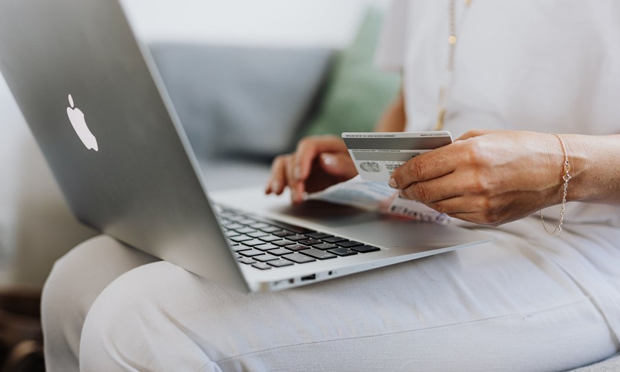 Pessoa usando cartão de crédito virtual em compra online no notebook