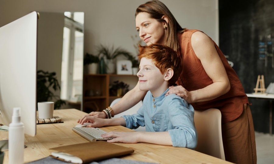Mãe e filho usando o computador para abrir conta digital para menores de idade