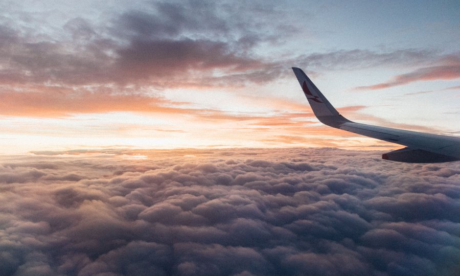 Asa de avião no céu representando viagens com pontos Livelo