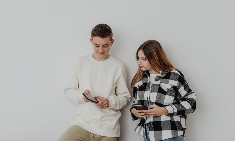 Adolescentes com celular representando conta digital para menores de idade
