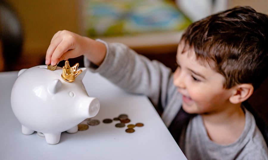 Criança guardando moedas, exemplo de educação financeira em conta digital para menores de idade