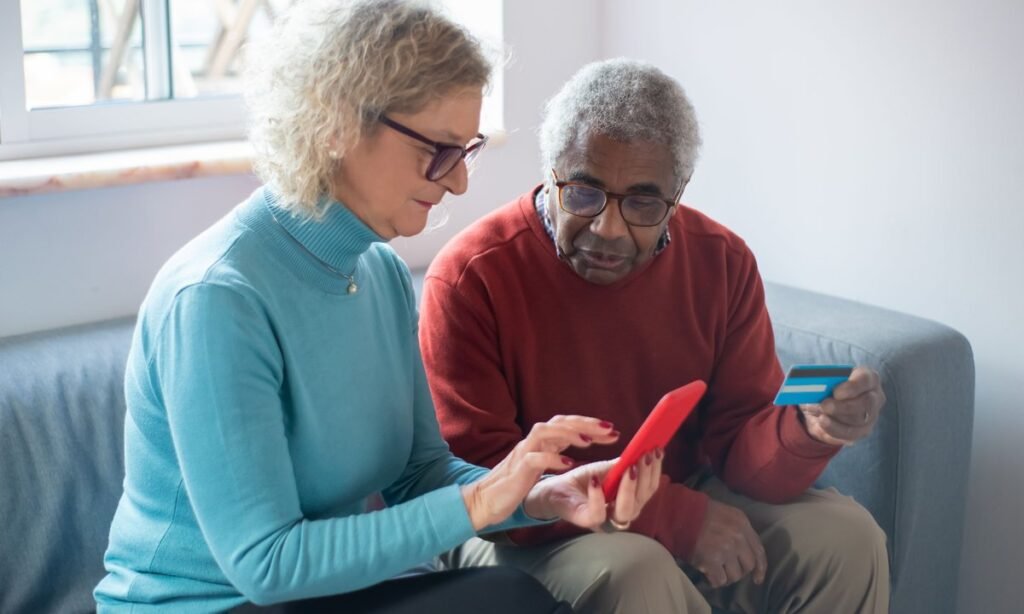 Casal de aposentados consultando o calendário do INSS de setembro no celular