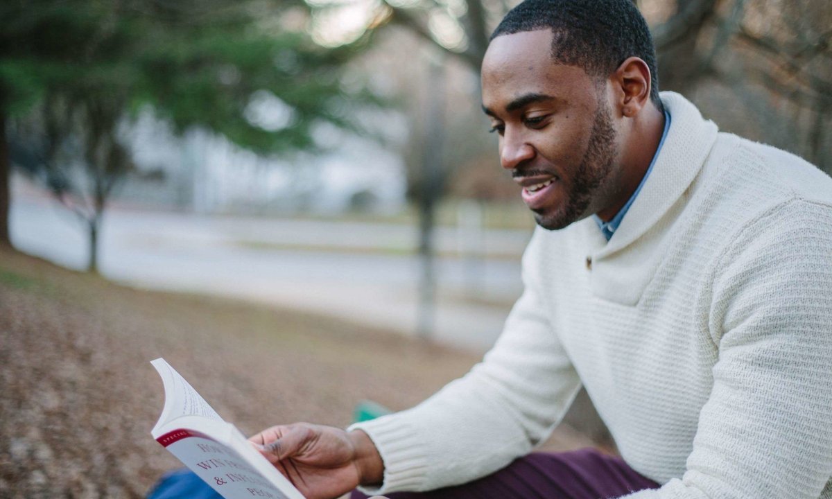 Homem lendo livro, tema dos livros para planejar a aposentadoria