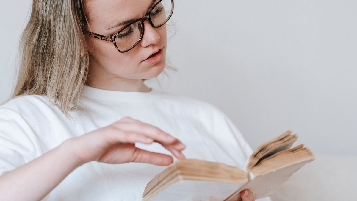 Mulher lendo um dos livros para sair das dívidas