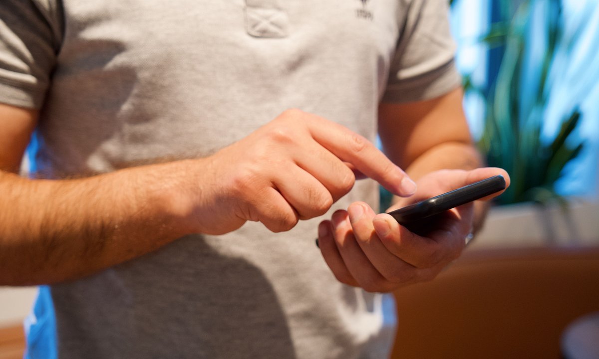 Homem usando o celular para abrir uma conta digital para negativado