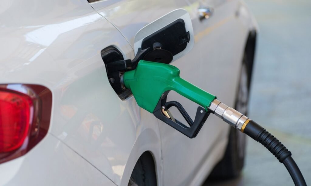 Bico de combustível abastecendo carro, escolha entre etanol ou gasolina