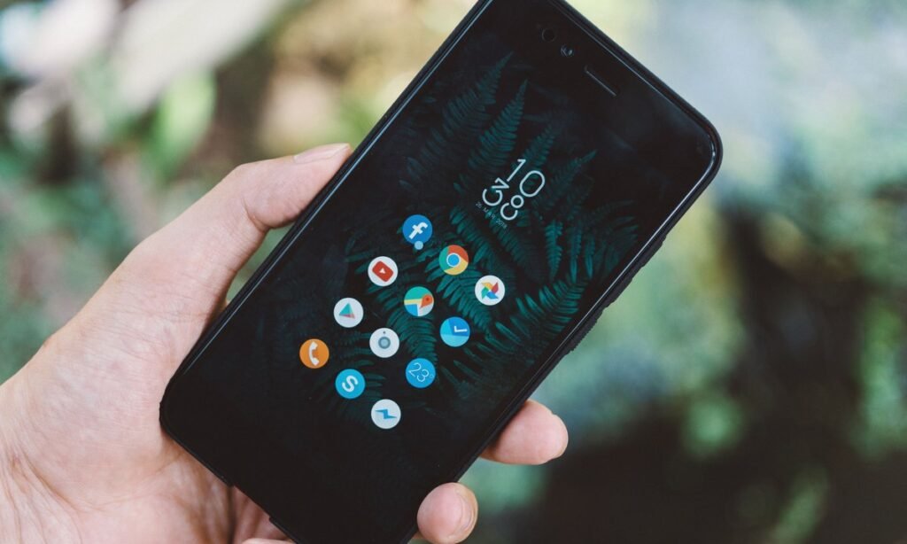 Mão segurando celular para consultar valores a receber do Banco Central