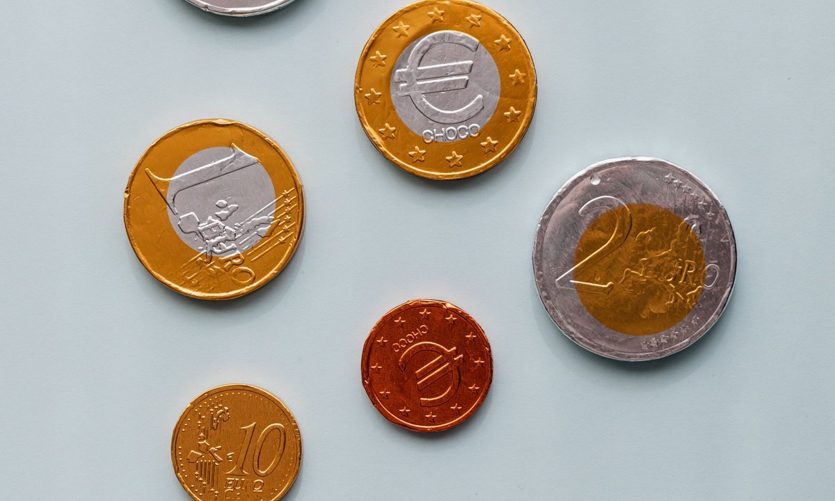 Moedas sobre a mesa, símbolo de como juntar 10 mil reais aos poucos