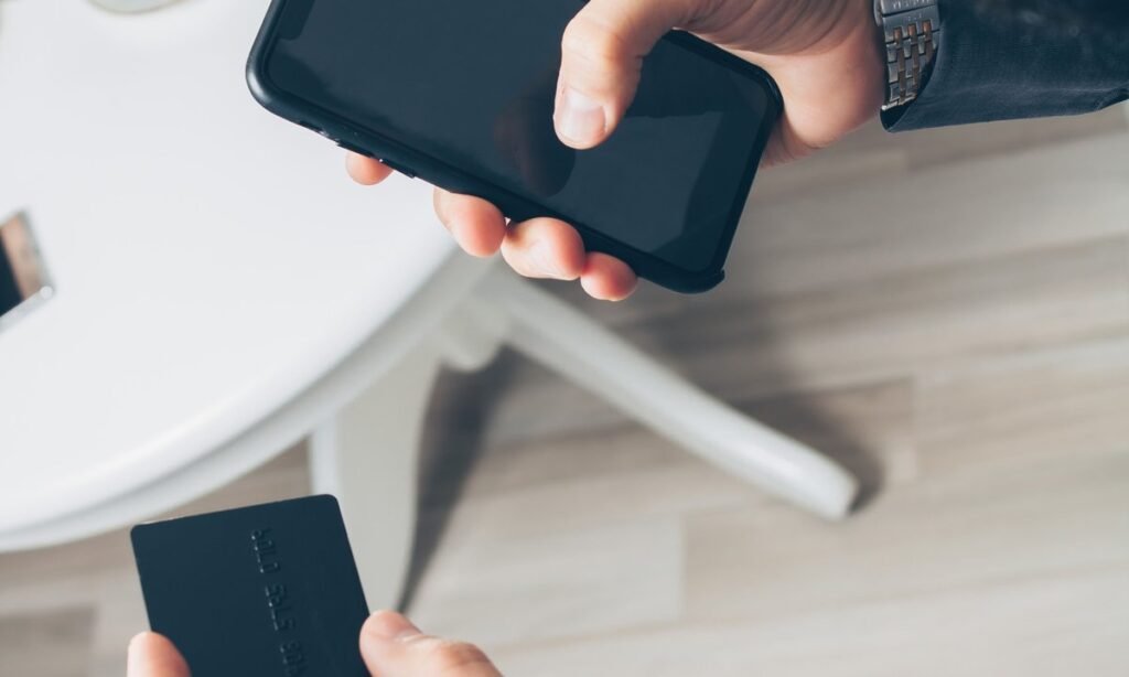 Pessoa segurando o celular para autorizar o Pix Automático no app do banco