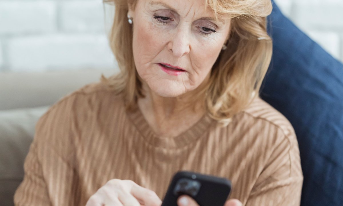 Aposentada acessa o aplicativo no celular, caminho digital da prova de vida do INSS