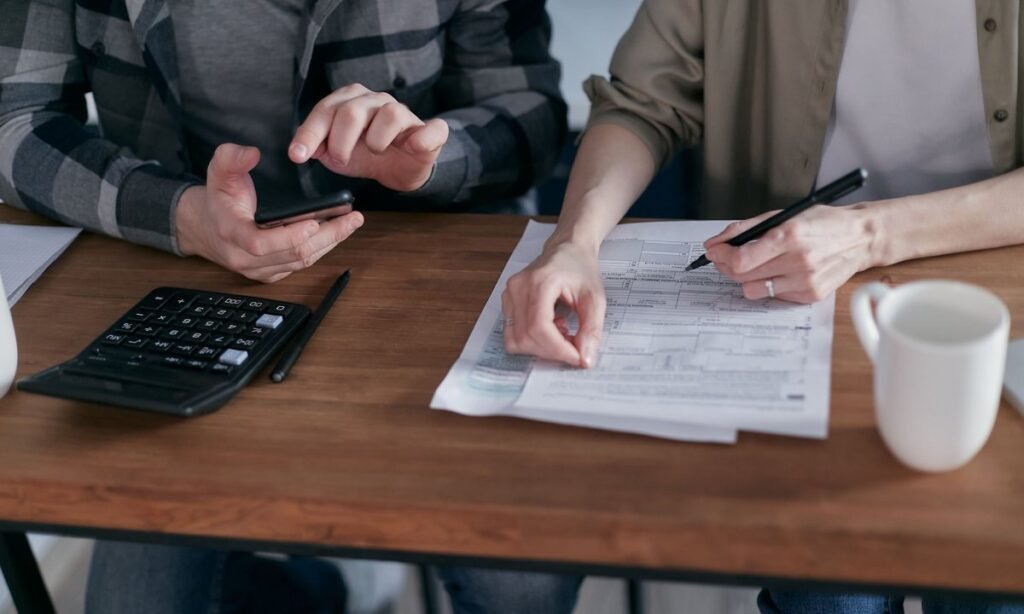 Calculadora e documentos na mesa para descobrir quanto sobra do aumento de salário