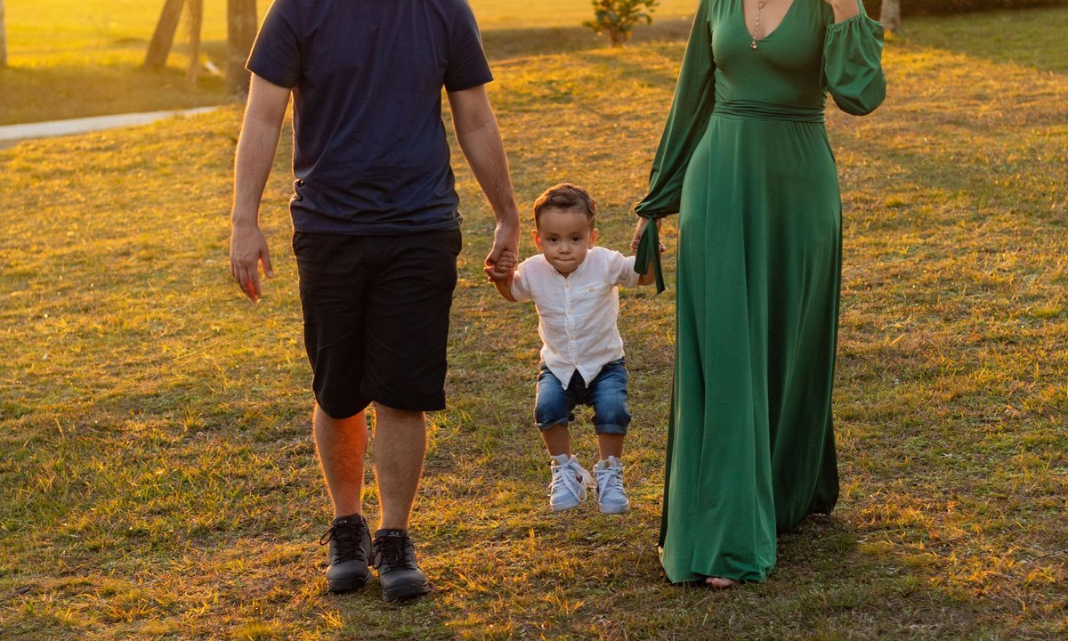 Família caminha com criança no campo, simulação do Bolsa Família de R$ 691
