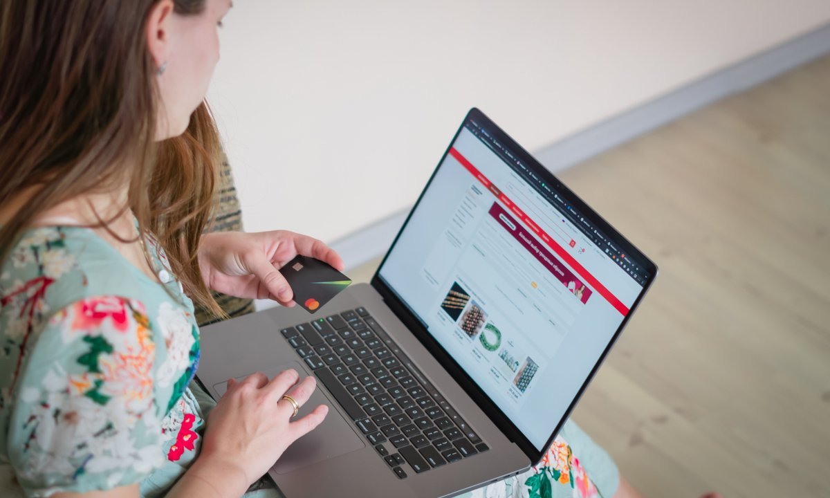 Mulher pesquisando preços no notebook para conferir o desconto da Black Friday