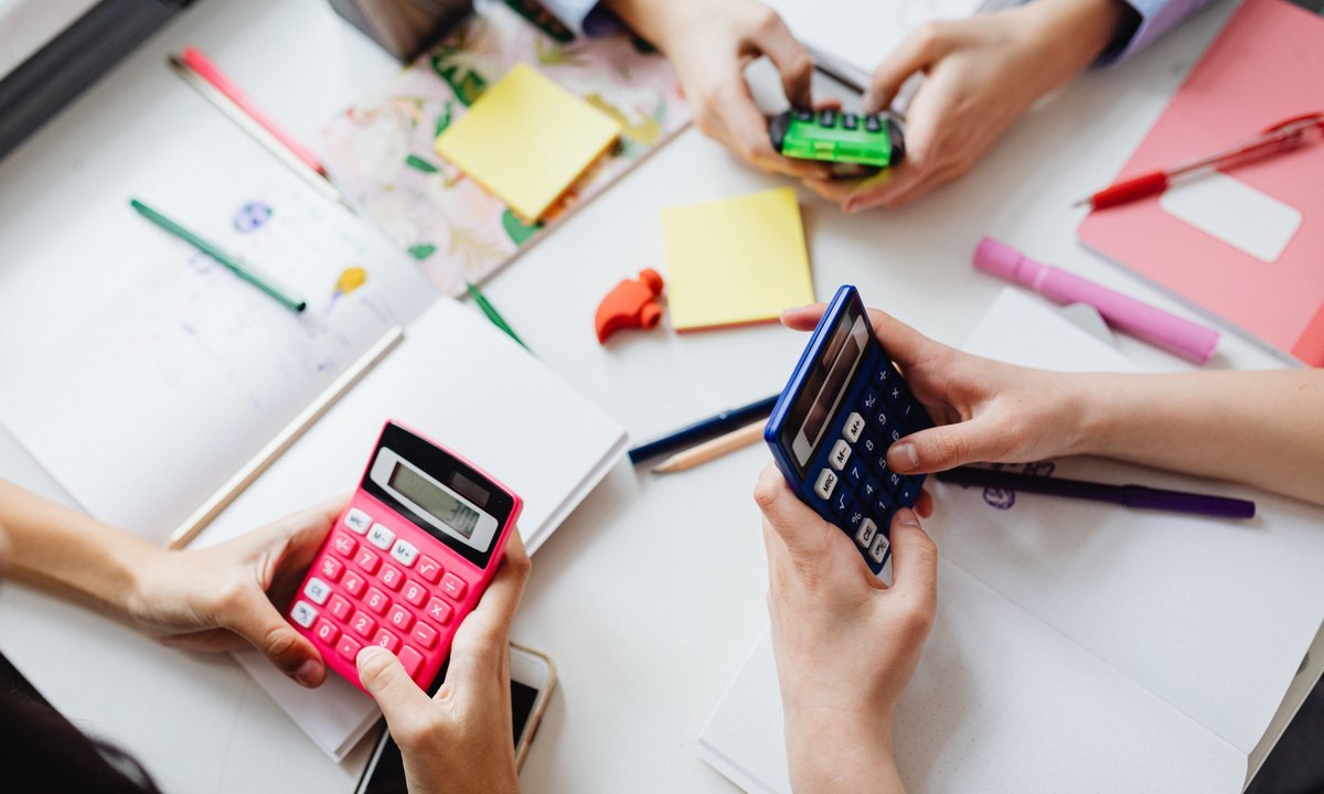 Pessoas fazendo contas na calculadora para comparar parcelado sem juros e Pix