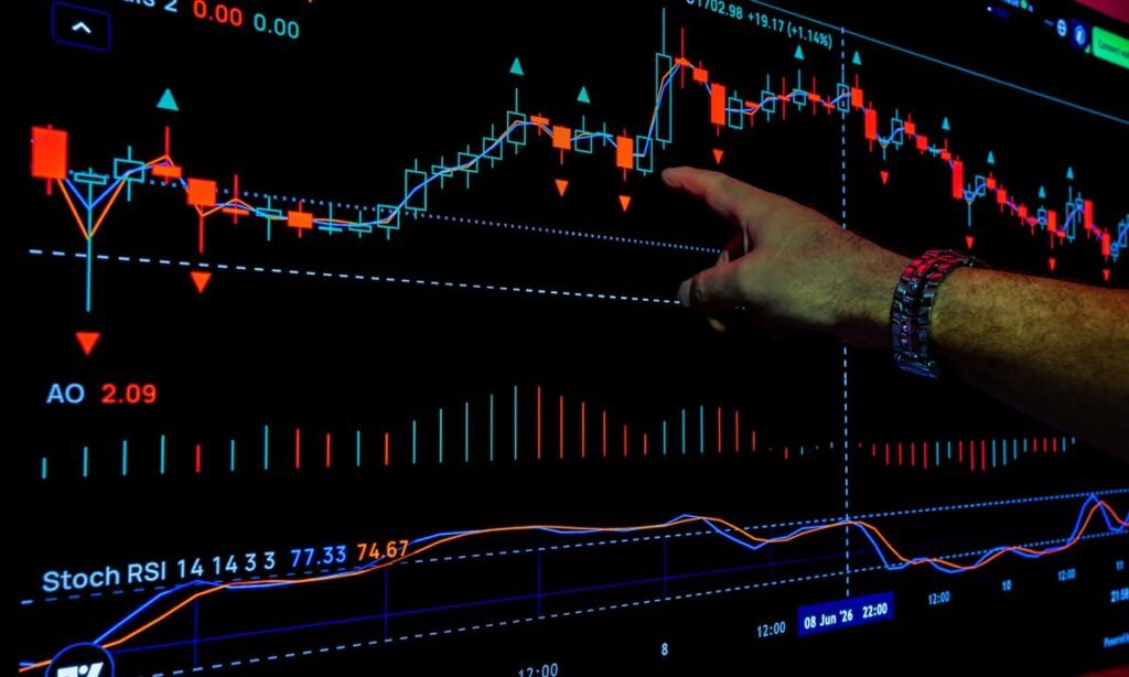 Dedo apontando gráfico da bolsa de valores em tela, tema do imposto sobre dividendos 2026