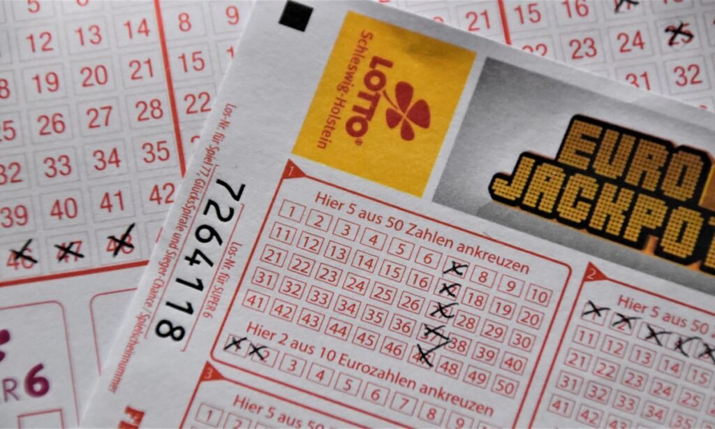 Volantes de loteria marcados com X sobre a mesa, simulando apostas da Mega Semana 2026