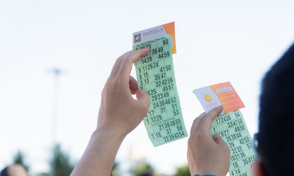 Mãos segurando bilhetes de loteria ao ar livre, em referência à Mega Semana 2026