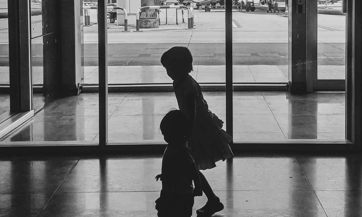 Silhueta de criança com mochila no terminal do aeroporto, viagem em família com passagem com milhas para terceiros