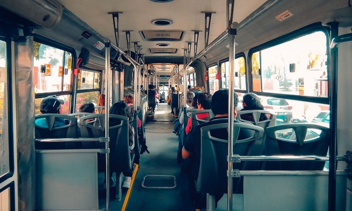 Interior de ônibus urbano com passageiros sentados, no transporte gratuito no segundo turno